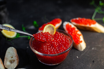 Red caviar on a dark background. Sandwiches with caviar