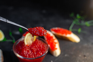 Red caviar on a dark background. Sandwiches with caviar