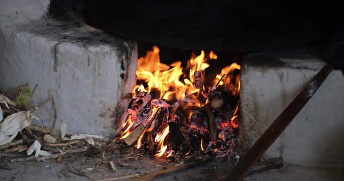 In the oriental courtyard, a fire burns in a medieval stove. lit the firewood to bake bread