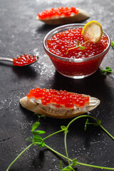 Red caviar on a dark background. Sandwiches with caviar