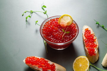 Red caviar on a dark background. Sandwiches with caviar