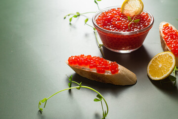 Red caviar on a dark background. Sandwiches with caviar