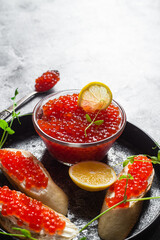 Red caviar on a dark background. Sandwiches with caviar