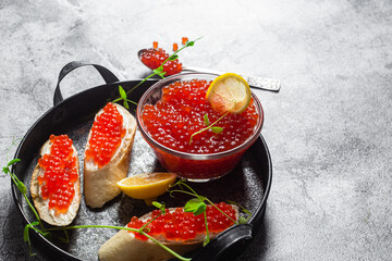 Red caviar on a dark background. Sandwiches with caviar