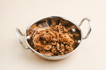 Slice beef with teriyaki sauce in small pan. Asian style food. Copy space.
