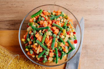 The process of cooking bulgur with vegetables. A dish of Middle Eastern cuisine is bulgur with carrots, string beans and mushrooms. The process of cooking vegetarian food. Bulgur with vegetable mix