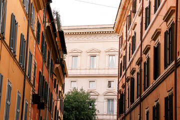 Fototapeta na wymiar Road in Rome, Italy with orange and red buildings along the sides leading to a creme building at the end.