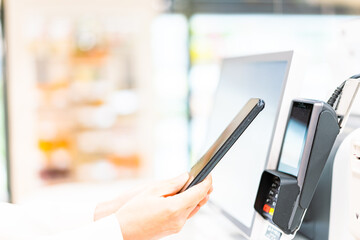 スマホ決済で支払う若い女性