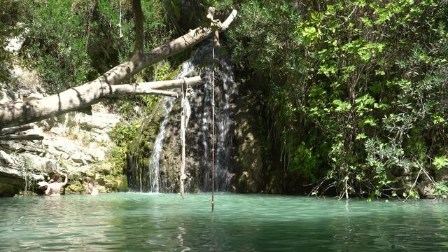 Cyprus, Paphos - August 2021: Adonis Baths Waterfalls. A two-level waterfall with a natural pool and statues of Adonis and Aphrodite.