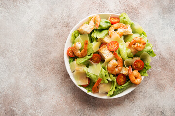 Italian caesar salad with shrimp, croutons and parmesan, top view