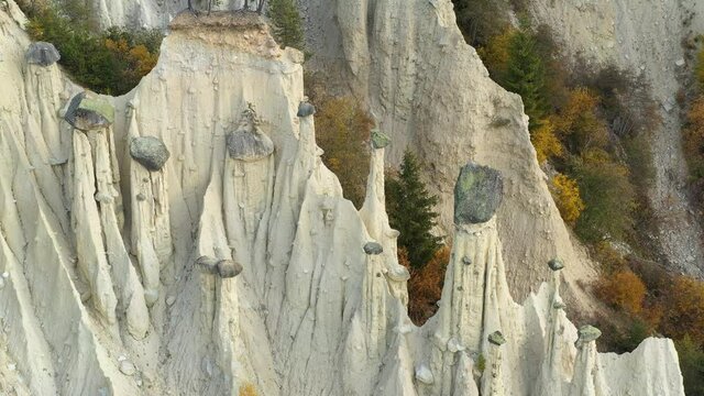 Aerial view on natural Earth Pyramids of Platten in autumn Dolomite Alps. Perca, Dolomites, Italy. UHD 4k drone video