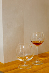 A glass of elite cognac on the bar. Wooden table background. Hard strong alcoholic drinks, spirits and distillates in glasses: vodka, cognac, tequila, scotch, brandy and whiskey, grappa, vermouth, rum