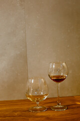 A glass of elite cognac on the bar. Wooden table background. Hard strong alcoholic drinks, spirits and distillates in glasses: vodka, cognac, tequila, scotch, brandy and whiskey, grappa, vermouth, rum
