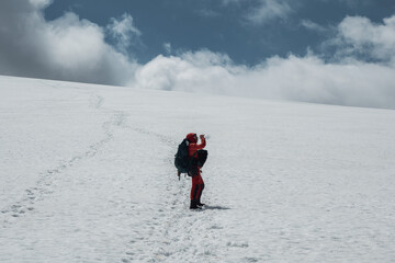 Fototapeta na wymiar Male climber drinks water on a snowy mountainside while climbing.