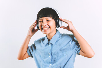Overjoyed by a confident young handsome mixed race youth boy wearing headphones as a Dj have fun and enjoy listening to favorite music dancing over a white background in a studio. For text copy space