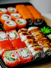 Japanese sushi food. Maki ands rolls with tuna, salmon, shrimp, crab and avocado. Top view of assorted sushi. Rainbow sushi roll, uramaki, hosomaki and nigiri.