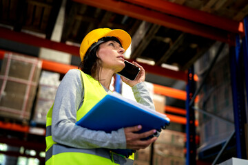 Adult caucasian woman talking by mobile phone in warehouse