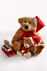 Vintage style teddy bears with Santa cap on white snow background