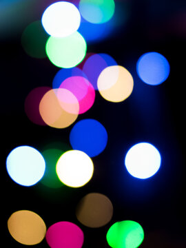Portrait view of out of focus decoration color lights .Circle bokeh shapes wallpaper or background for texts, images and articles, blank space with blurred background.Christmas light.