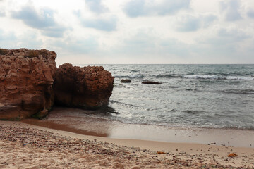Ocean shore front and big rocks on a cloudy day