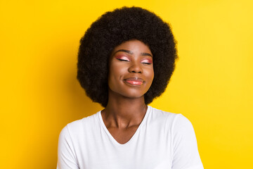 Fototapeta Photo of relaxed afro american young joyful woman closed eyes smile isolated on yellow color background obraz