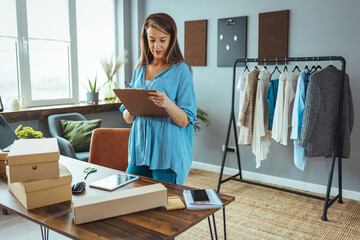 Mature woman at online shop. She is owner of small online shop. Receiving orders and packing boxes for delivery. Online shopping makes happy a lot of people. Woman packing item that she sells online © Dragana Gordic