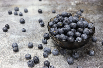 Delicious organic blueberries in a bowl on a dark background. Healthy food concept.