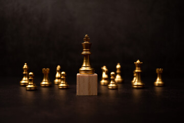 Golden king chess standing on a wooden stand. The concept of Leaders in good organizations must have a vision and can predict business trends and assess competitors