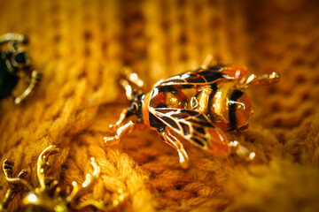 brooch jewelry Insect breaks on a yellow knitted sweater, an inexpensive jewelry jewelry in the entomological style