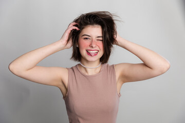 Fototapeta premium It's time to go to the beauty salon. Casual woman face expressions she does not go to spa, hair salon or beauty salon for long time. over gray background copy space.