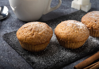 Carrot sweet muffins. Carrot cupcakes with sugar and cinnamon on a dark background