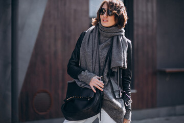 Naklejka premium Young woman model in leather jacket outside the street