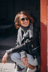 Young woman model in leather jacket outside the street