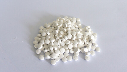 Handful of white pills on a white background. Isolated image on a white background.