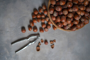 Hazelnuts with nutcracker on gray background. Top view of nuts.