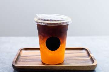 Iced americano mixed orange juice in plastic cup.