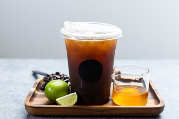 Iced coffee mixed honey lemon in plastic cup.