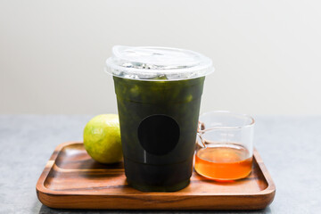Iced green tea mixed honey lemon in plastic cup.