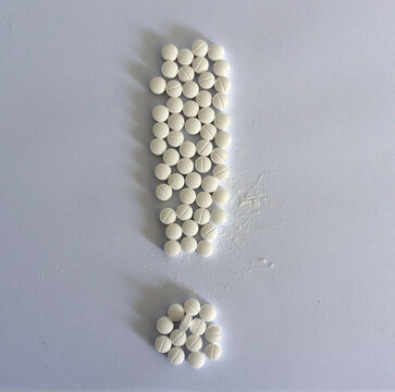 Pills in the form of an exclamation mark. Isolated image on a white background.