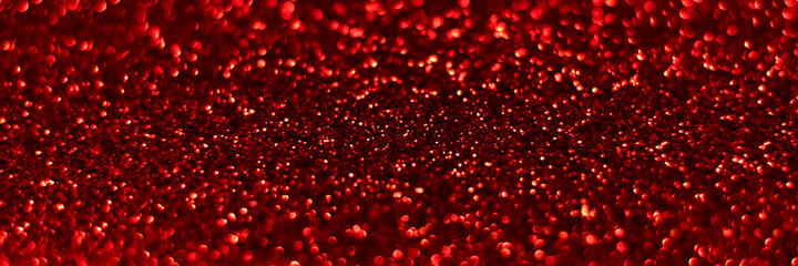 Red sparkling glitter bokeh background, christmas texture. Holiday lights. Abstract defocused header. Wide screen wallpaper. Panoramic web banner with copy space for design