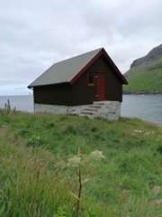 Traditional old cute stone houses with grass roofs on the Faroe Islands with a mountain view