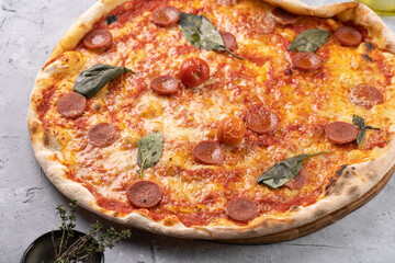 Freshly baked traditional mediterranean pizza with tomato sauce marinara, mozzarella cheese, pork sausage salsiccia and basil