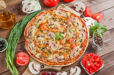 Delicious fresh homemade pizza with ham on wooden background with selective focus