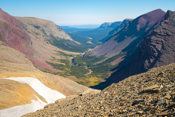 Fototapeta premium View above a mountain valley seem from the Siyeh Pass in the Glacier National Park, Montana, USA on a sunny day of late summer. Hiking in the wilderness of American Rockies.