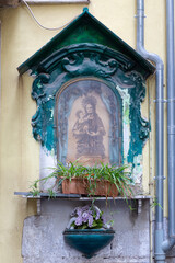 Characteristic house shrine with saints and madonna with child in Naples, Italy.