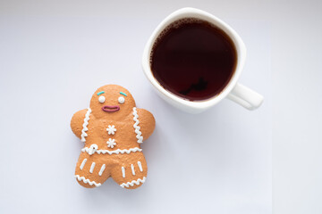 The Gingerbread Man and a white cup of tea on white background