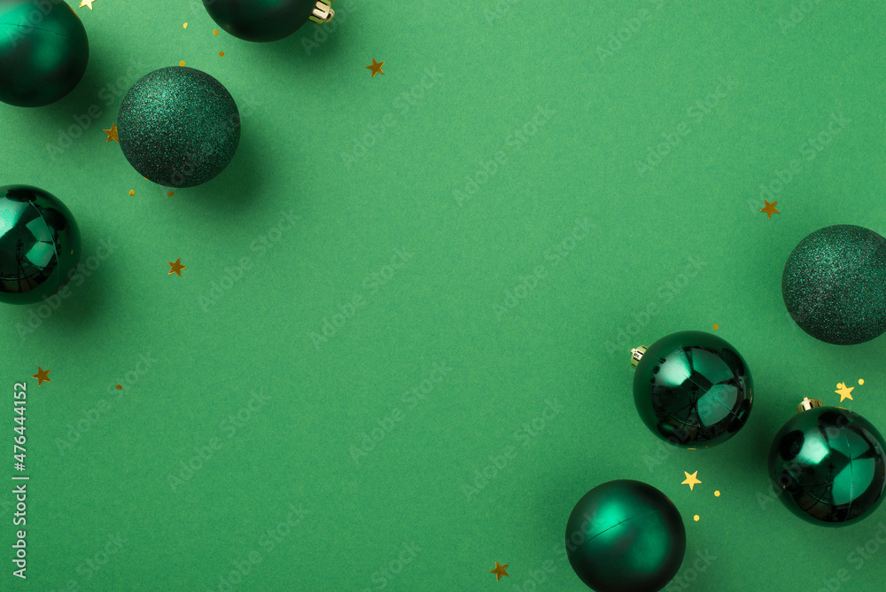 Wall mural top view photo of green christmas tree balls golden star shaped confetti and sequins on isolated gre