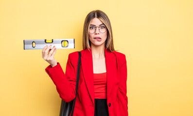 architect woman looking puzzled and confused and holding a level balance