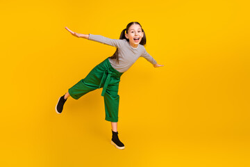 Fototapeta na wymiar Full size photo of young school girl happy positive smile hands wings fly air isolated over yellow color background