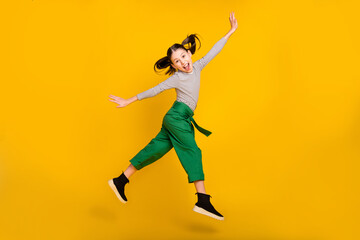 Fototapeta na wymiar Full size profile side photo of young girl happy positive smile grimace tongue-out jump isolated over yellow color background